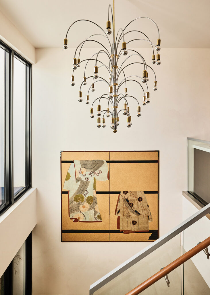 The staircase area features a chrome and brass Italian 1970s vintage chandelier from 1stdibs; and a two panel Japanese screen, ‘Tagasode/Whose Sleeves?’ from Naga Antiques.