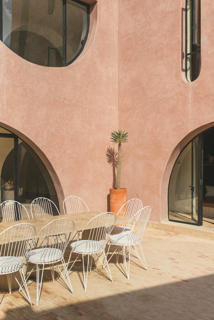 The courtyard features a travertine table with bespoke metal seats crafted by local metalworkers