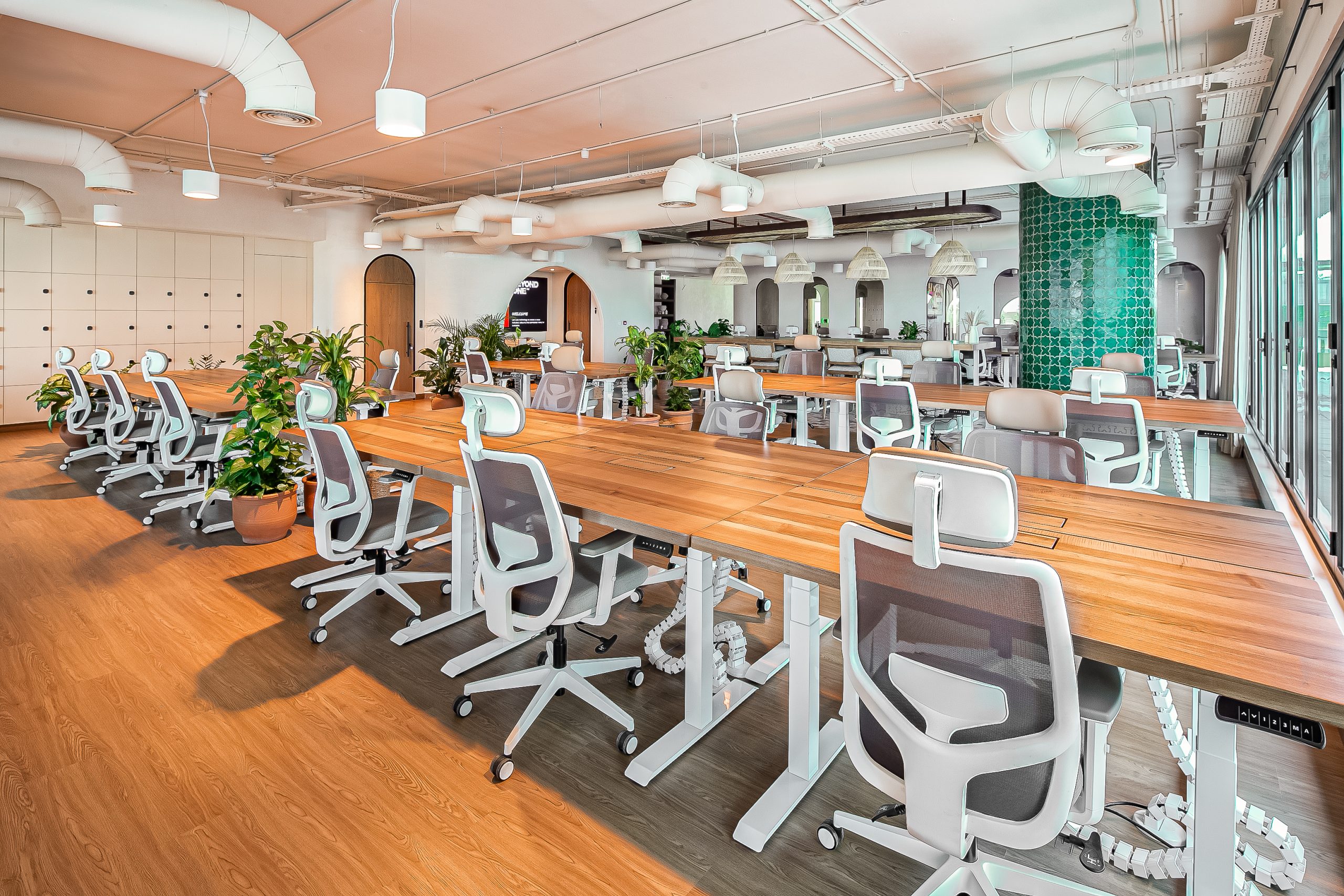 main office floor with ergonomic chairs and wooden tables at Beyond One's office