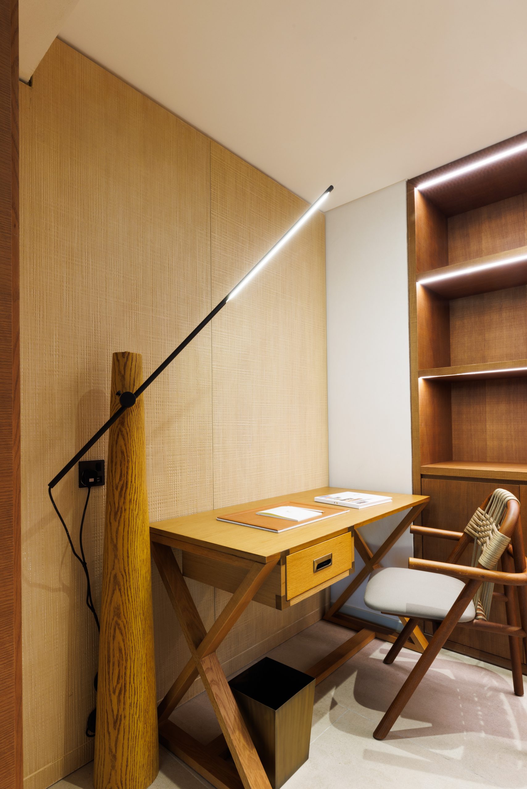 a desk, chair, lamp and bookcase in warm neutral tones 