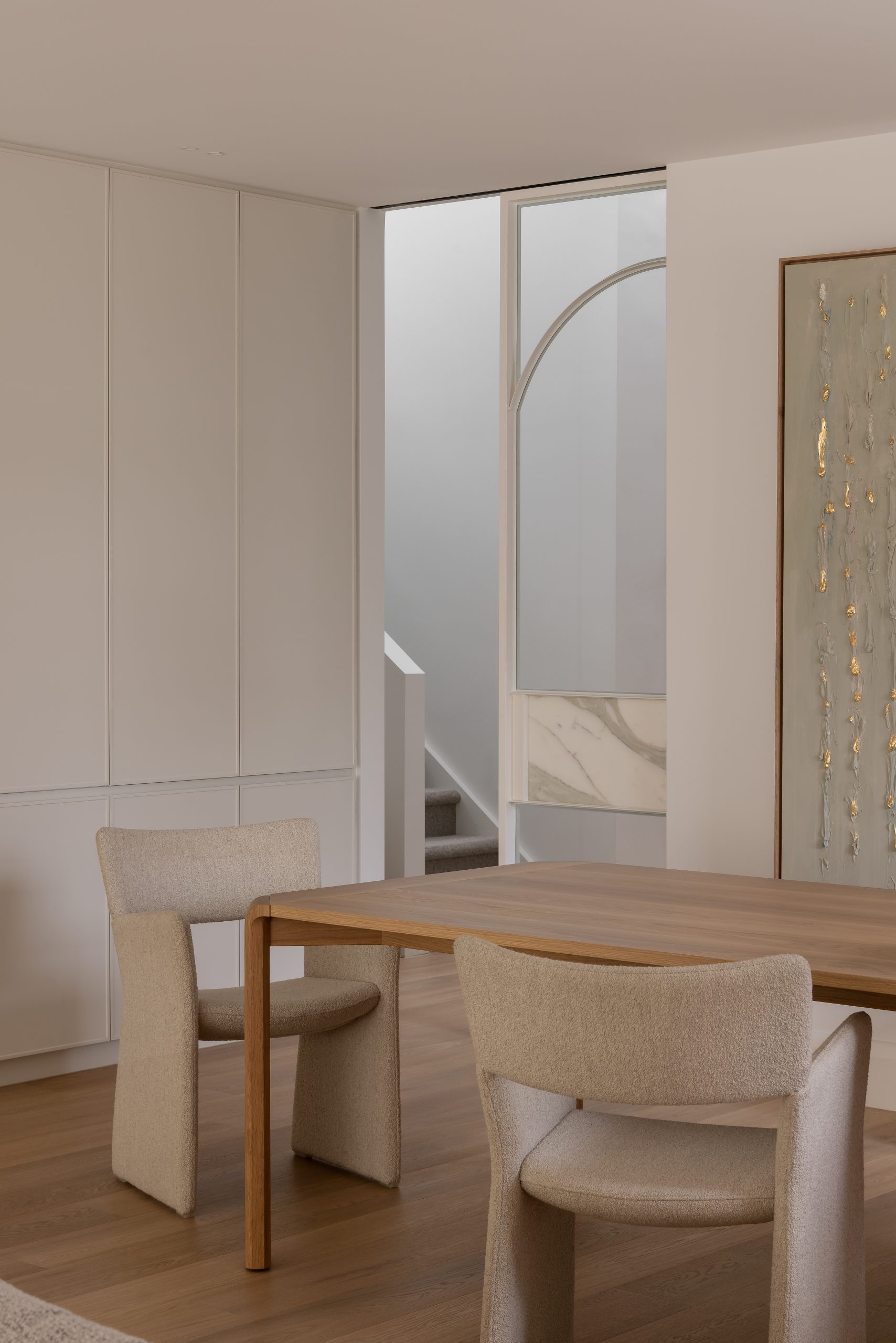 a table and chair infront of a transparent door with marble finishings