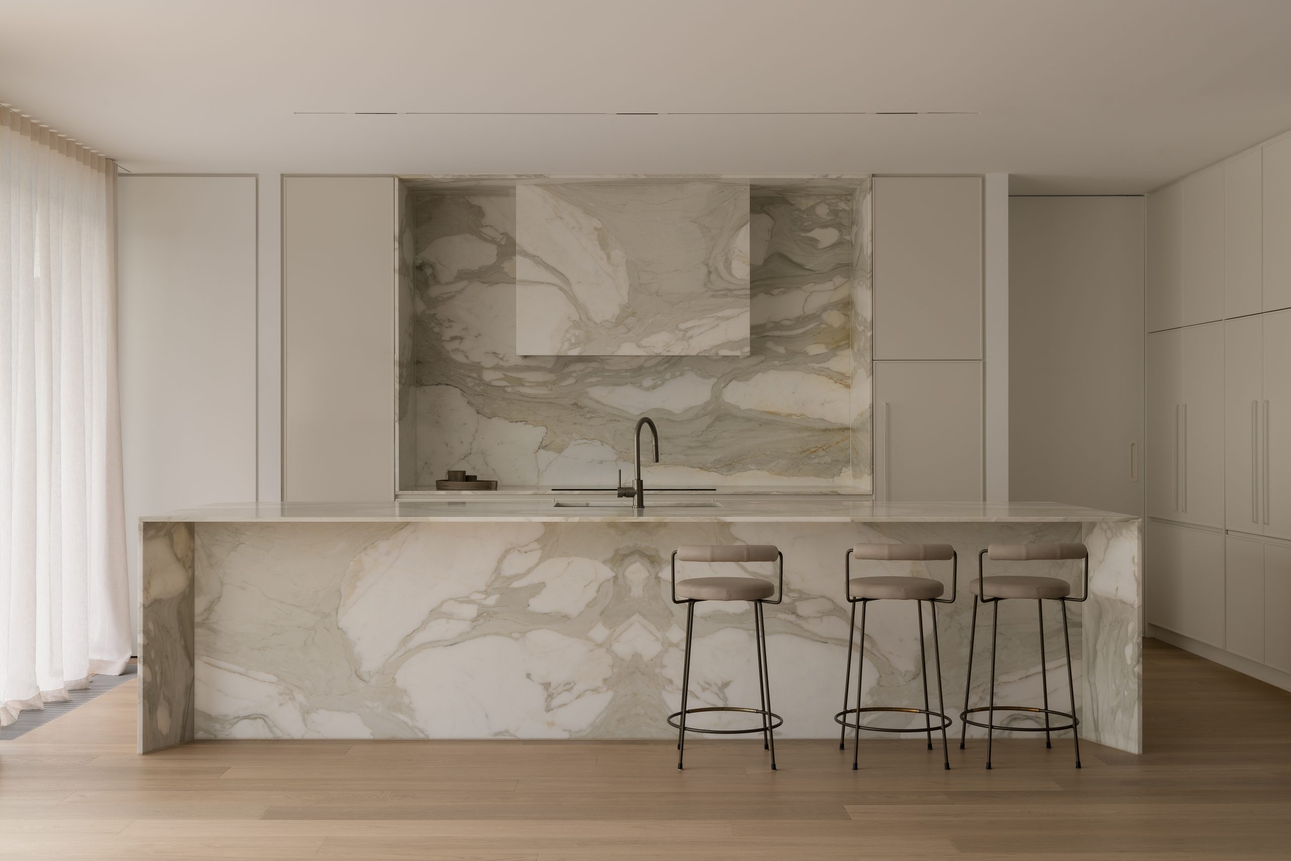 marble minimalist kitchen with an island and stools