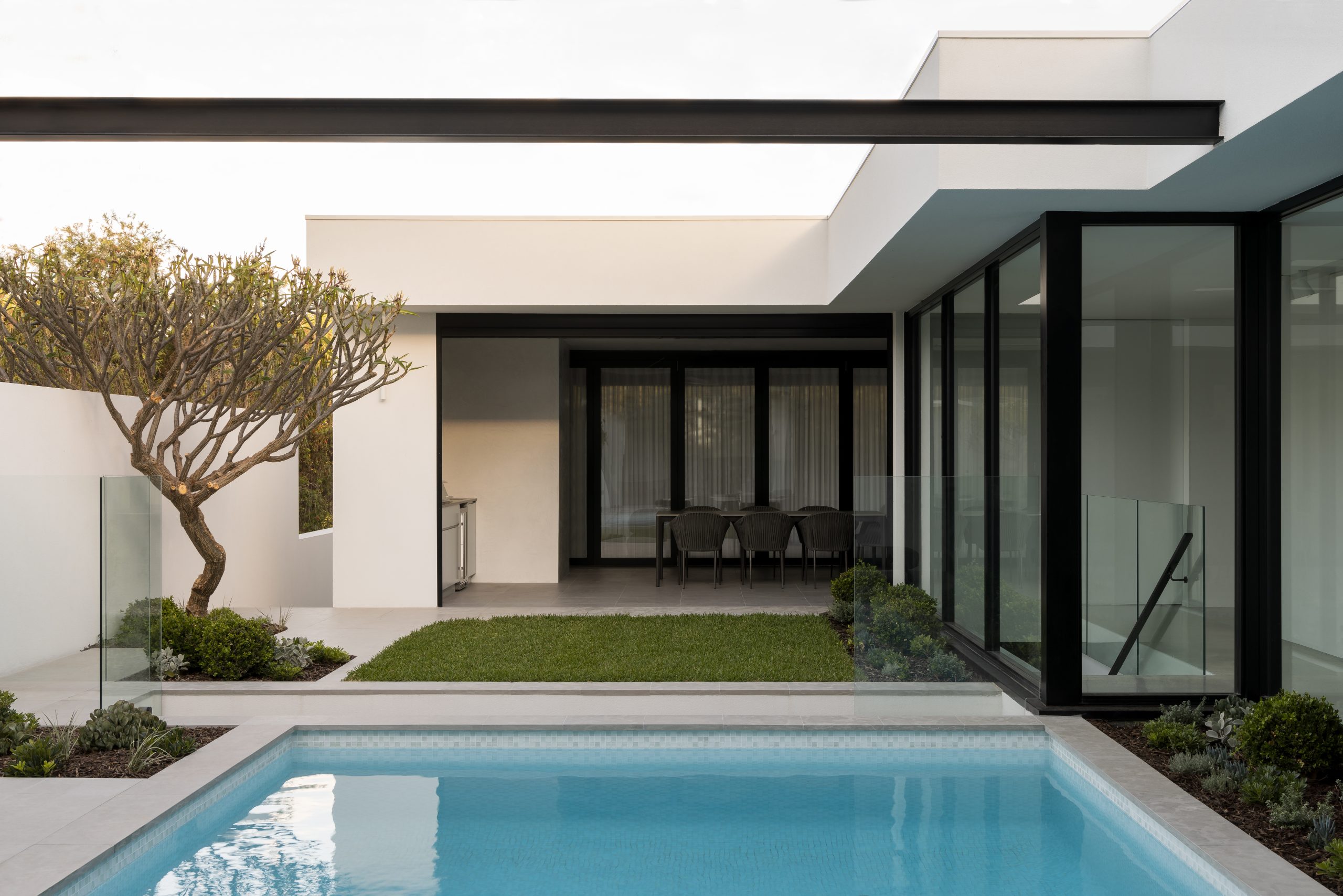 exteriors of the woodland home, seamless integration of outdoor pool with indoor spaces