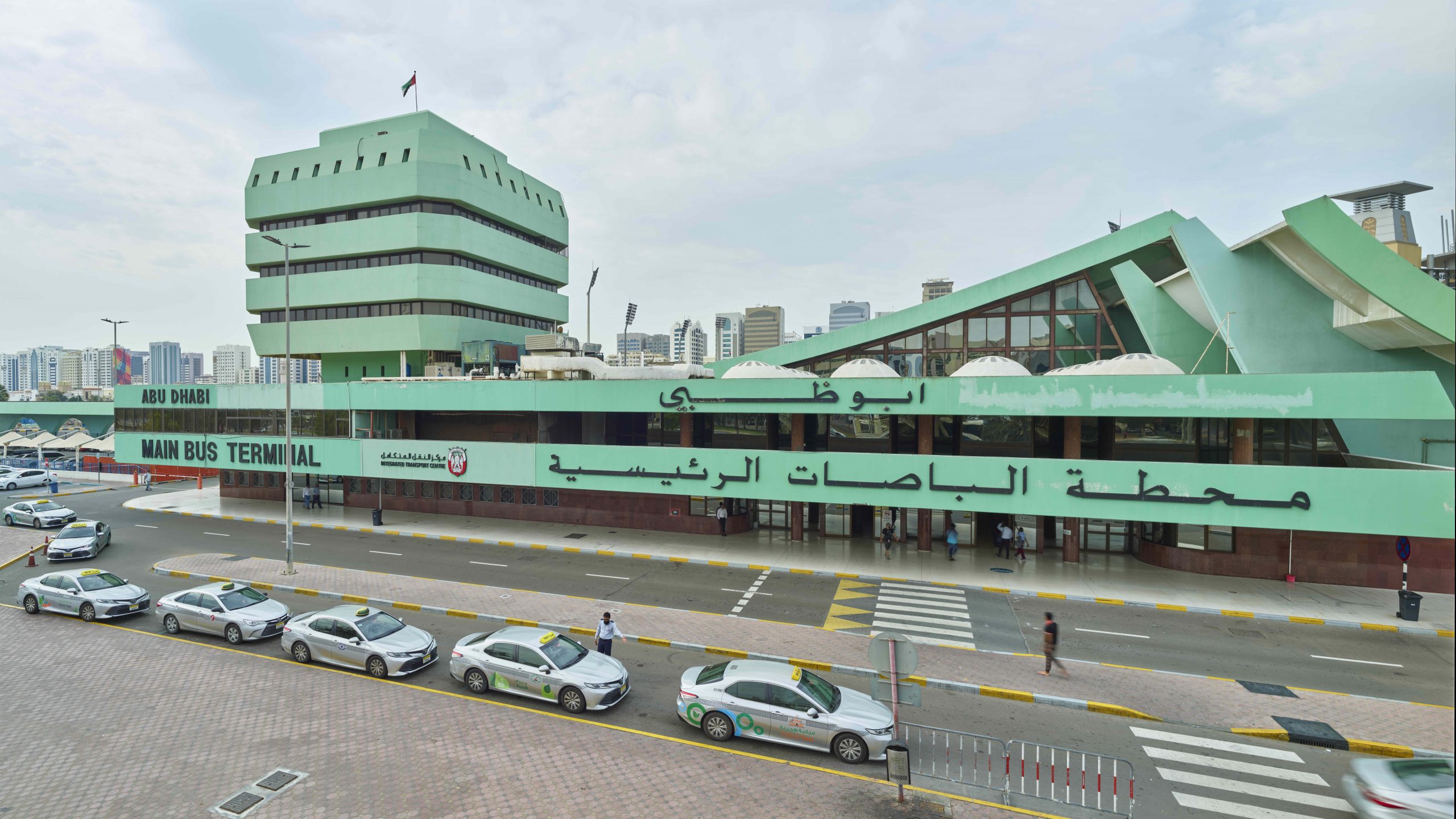 A green building with cars parked on the side for Biennial